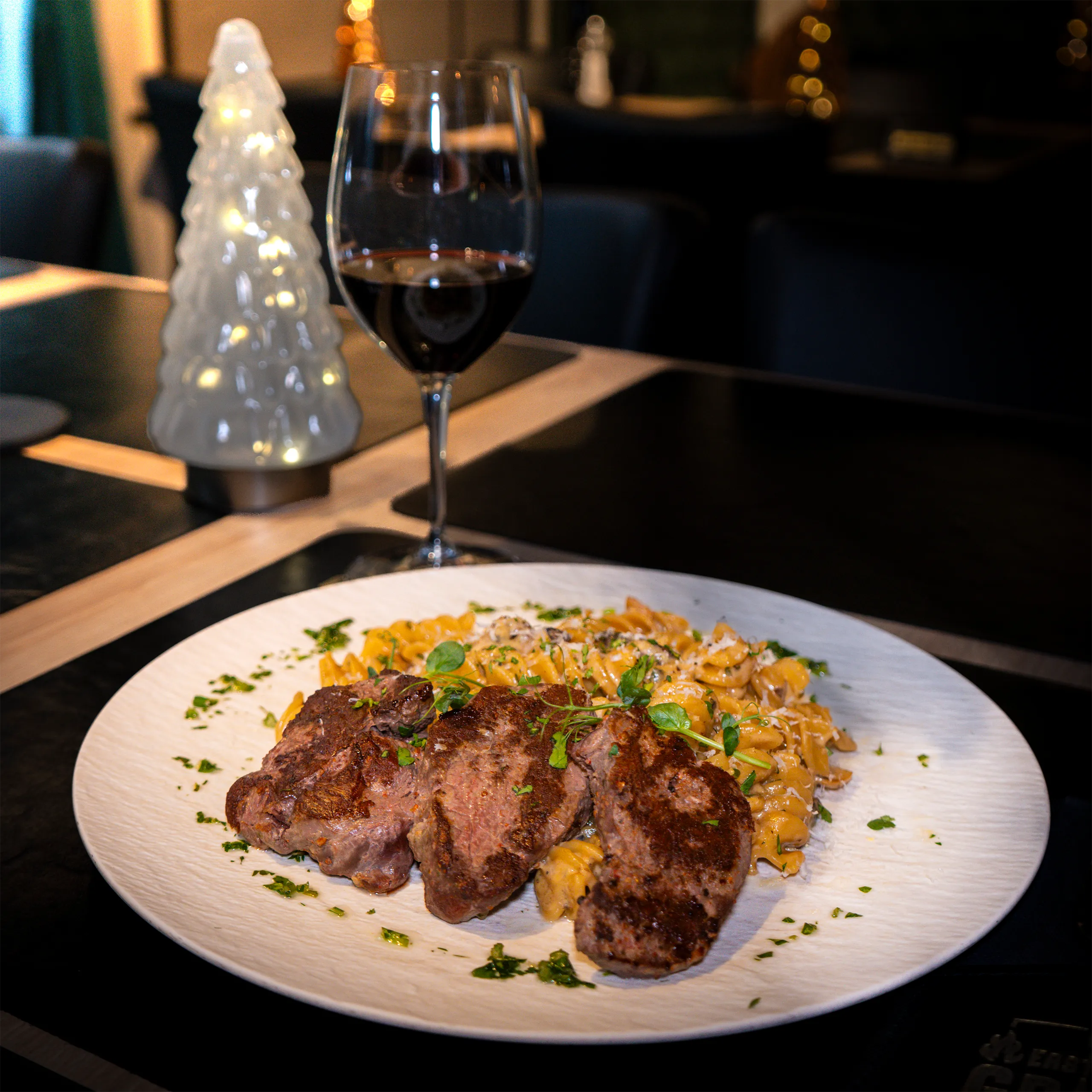 Gegrilltes Fleisch mit cremiger Pasta und Rotwein im EastSide Grill Wörgl